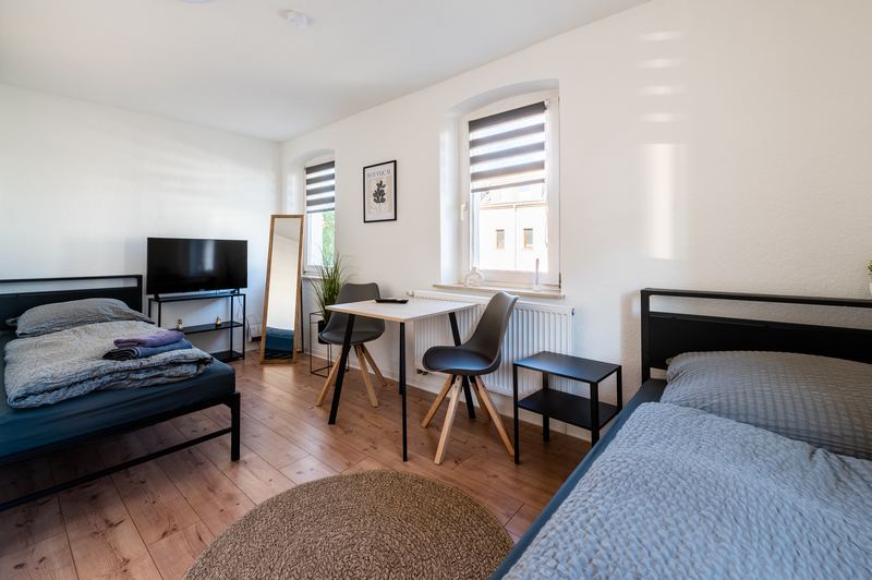 Helles Schlafzimmer mit zwei Betten und Tisch