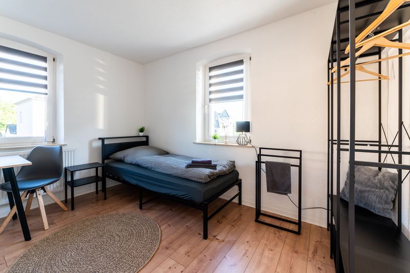 Schlafzimmer mit Einzelbett, Sitzplatz und Kleiderstange